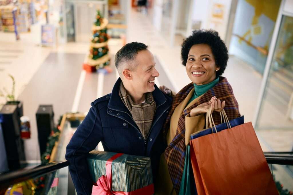 Happy couple enjoying in Christmas shopping in the mall.