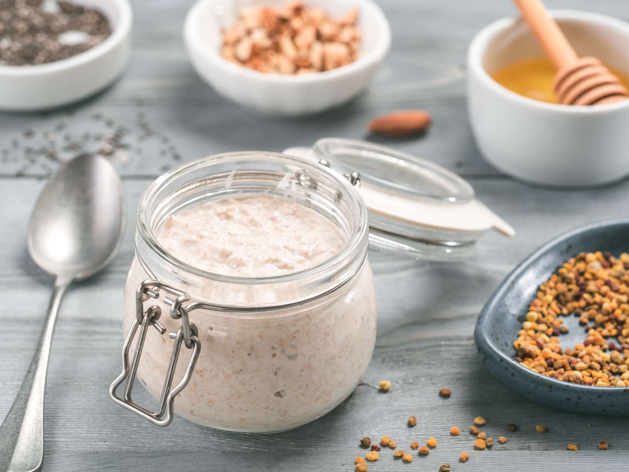 Overnight oats in jar and ingredients on gray wooden table
