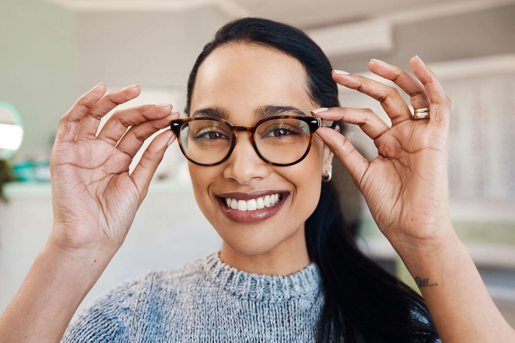Shot of a young woman buying a new pair of glasses at an optometrist store